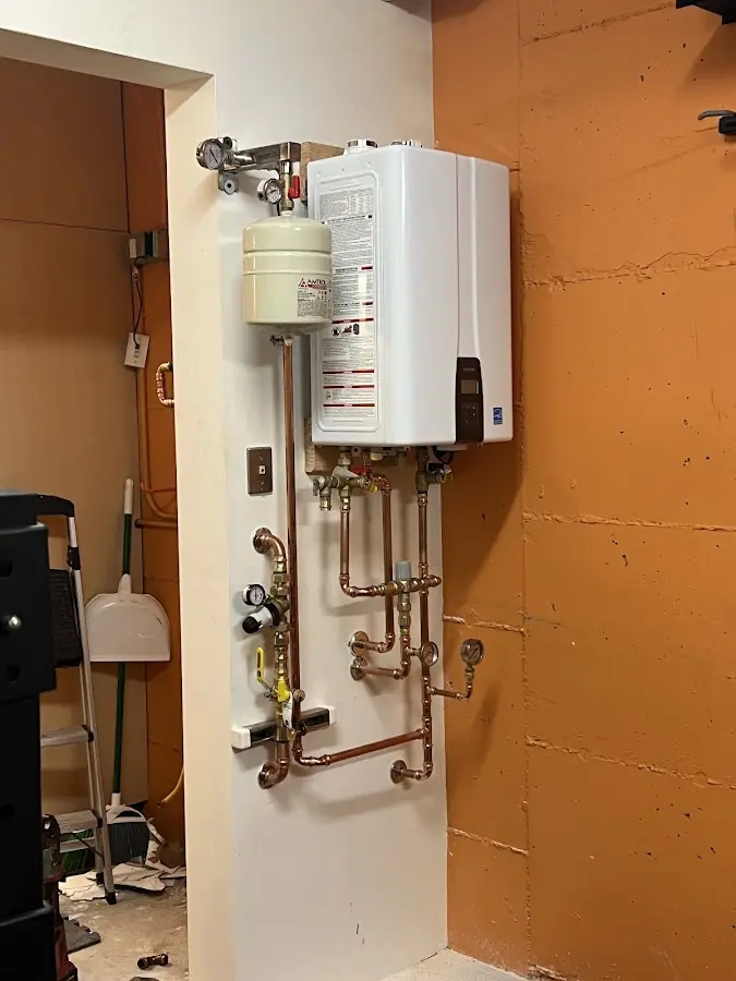 Plumbing technician inspecting water heater connections in Humble